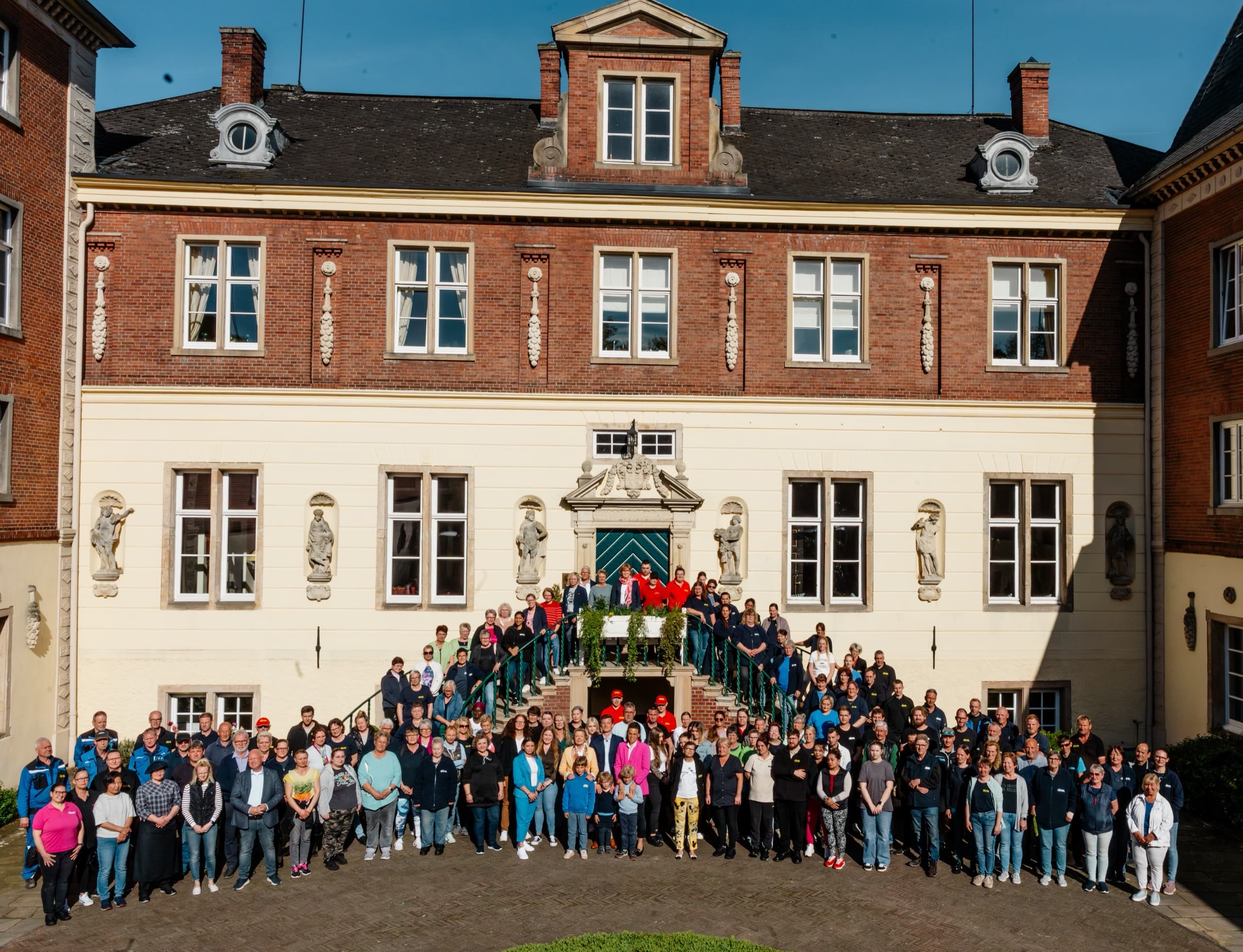 Gesamtteam Schloss Dankern (~120 Personen) vor dem historischen Schlossgebäude
