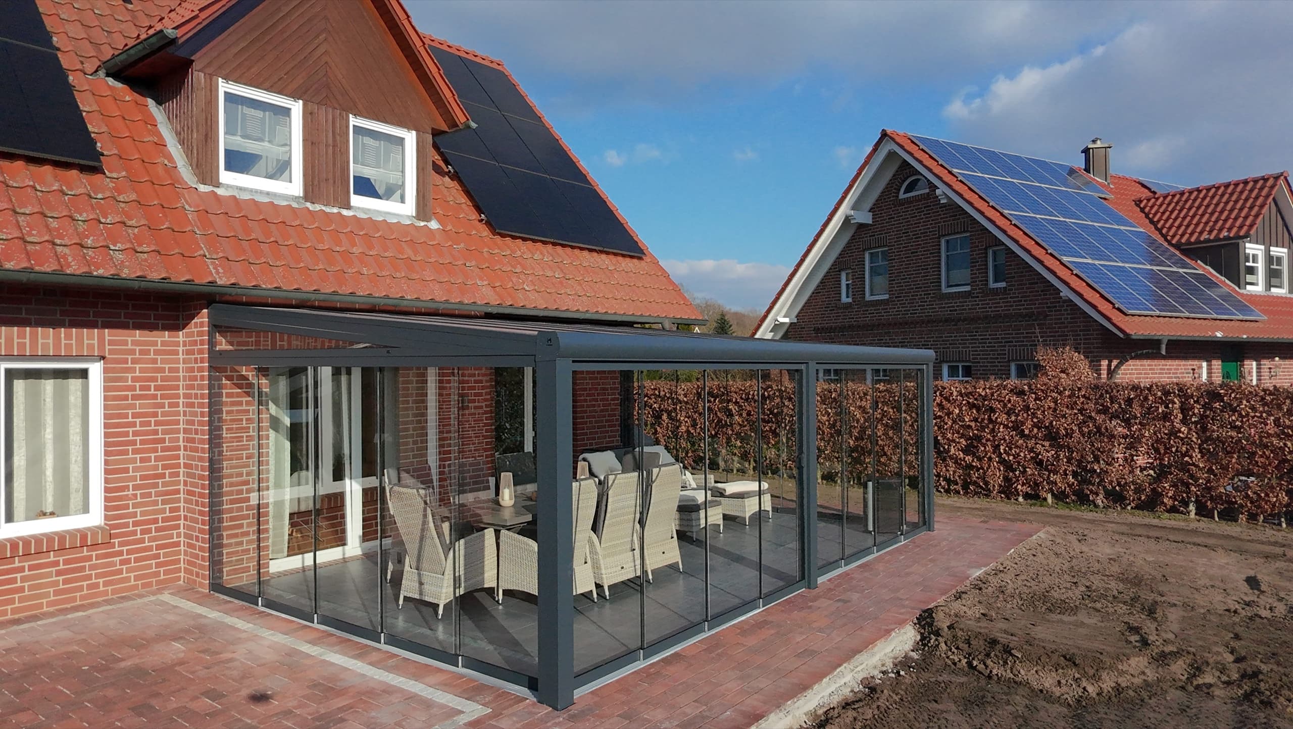 Terravista Meppen Kaltwintergarten mit umlaufenden Glasschiebewänden an Reihenhaus, Drohnenaufnahme