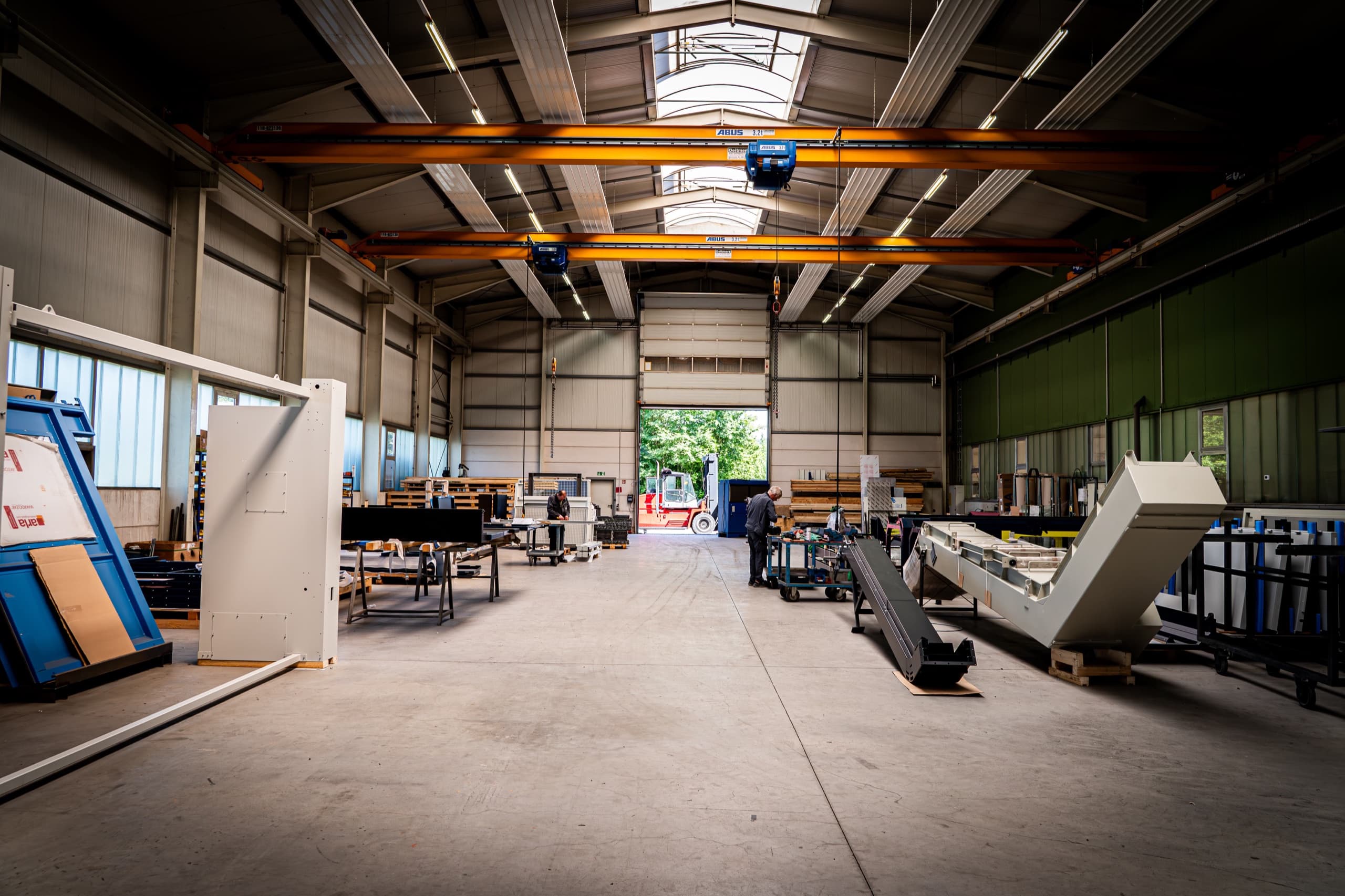 Weite Produktionshalle von AXA Maschinen und Armaturen mit Brückkran und Metallbauteilen
