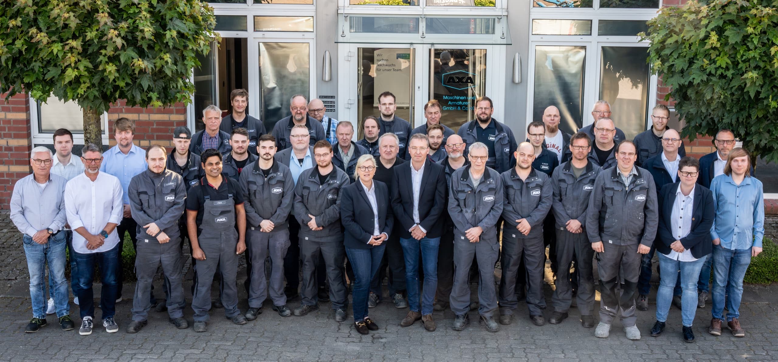 Gesamtteam AXA Maschinen und Armaturen, ca. 35 Mitarbeitende vor dem Firmengebäude