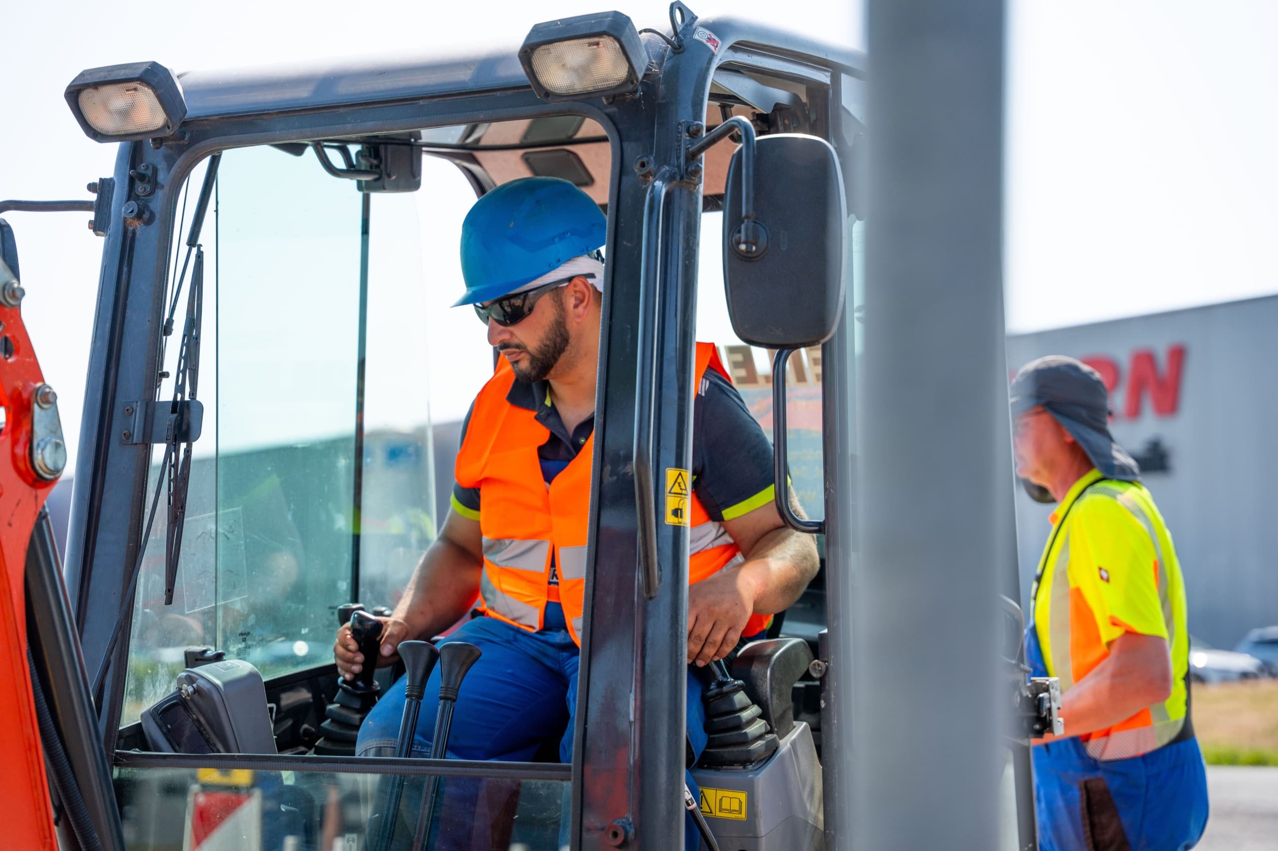 Zwei Circet Eilers Monteure besprechen Arbeit an rot-weißer Absperrung auf Baustelle