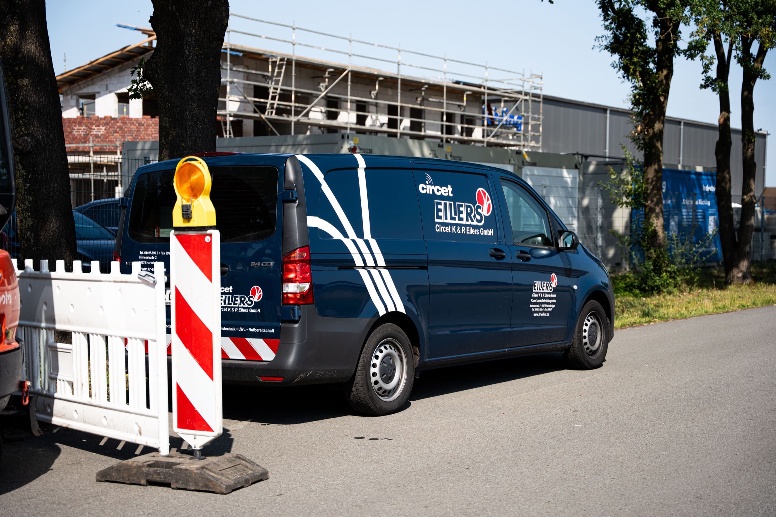 Blauer Eilers-Transporter an Baustelle mit rot-weißen Absperrgittern