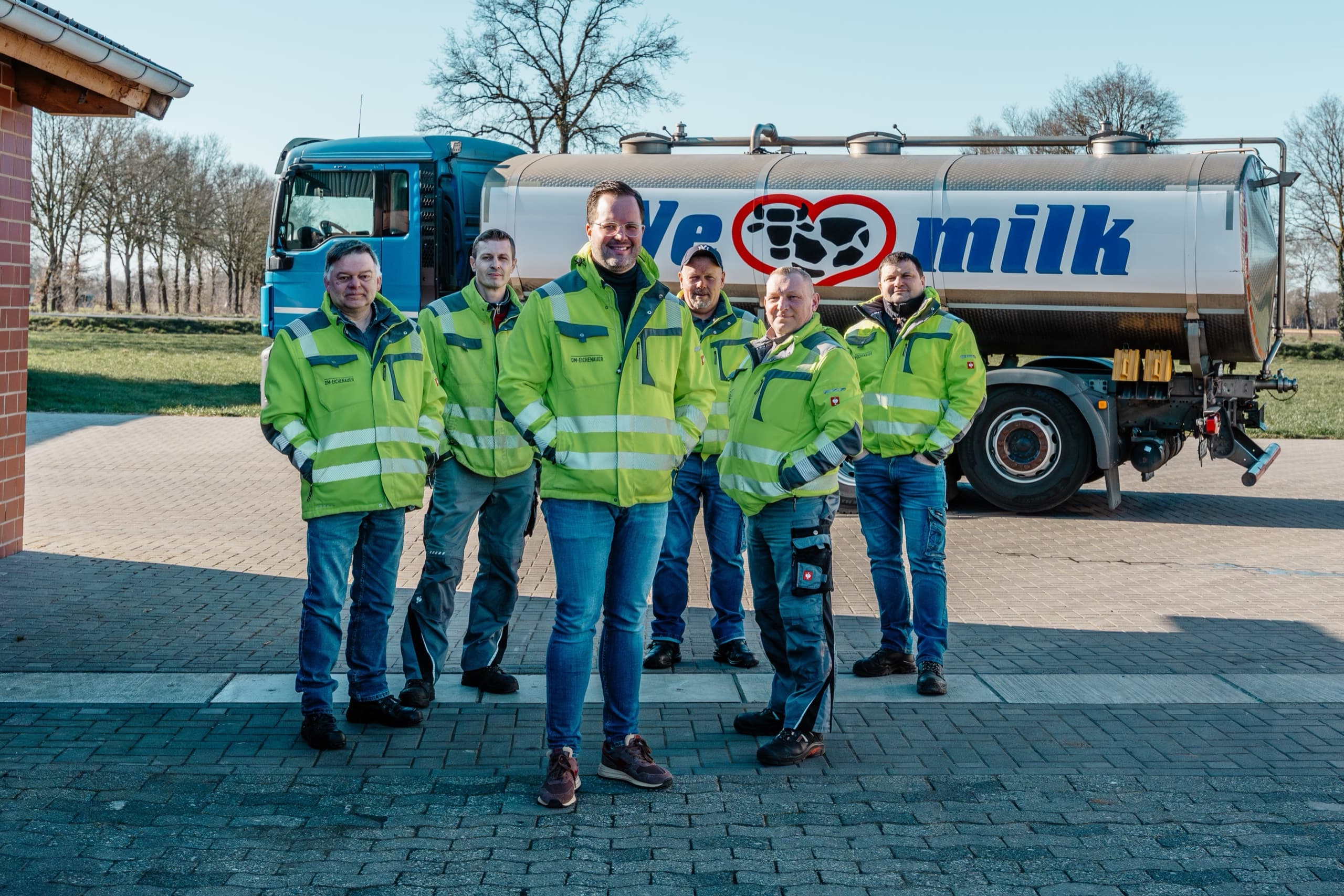 Sechs DM-Eichenauer Fahrer Team-Foto in gelben Warnwesten vor Mertens-Tanklastwagen