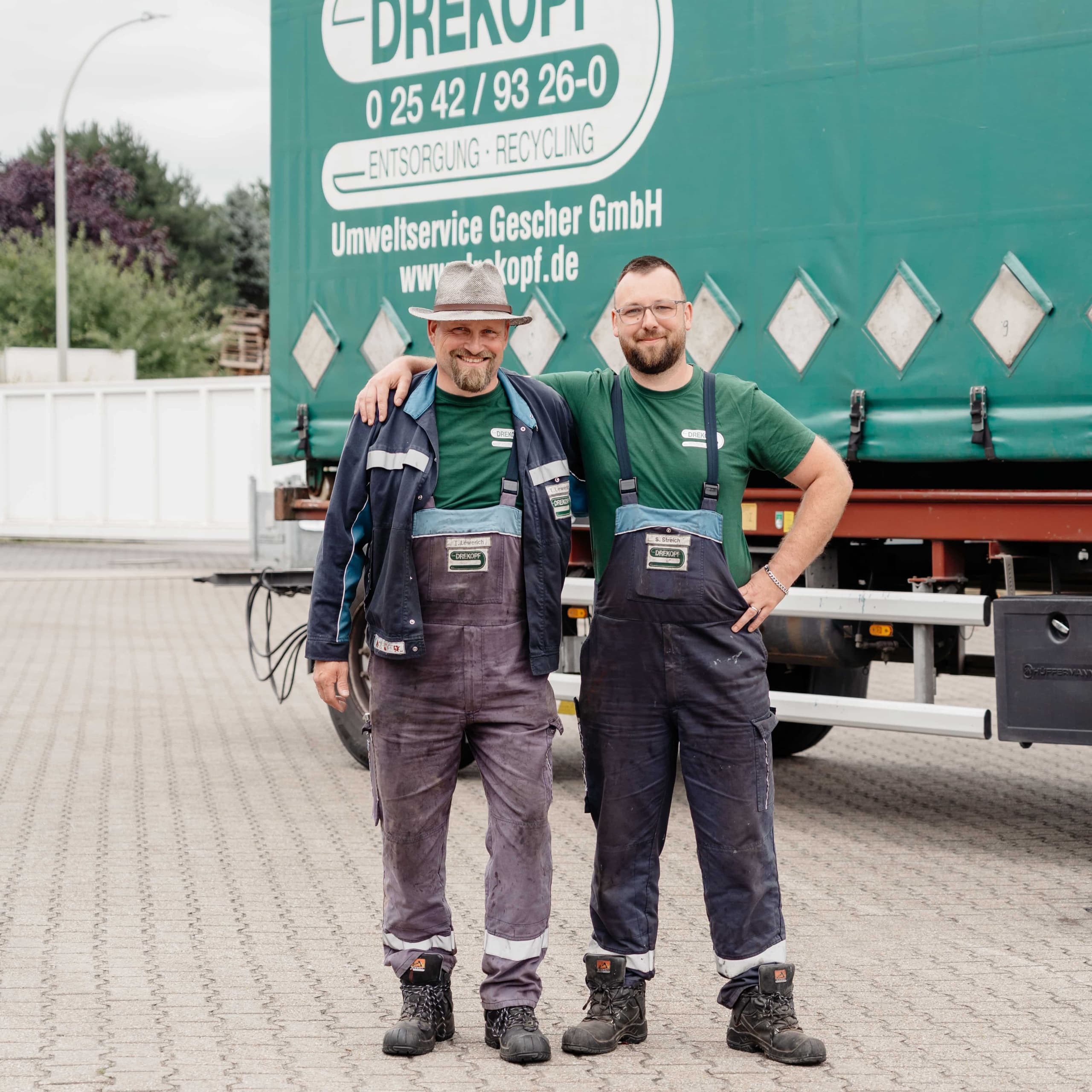 Zwei Drekopf Fahrer in grünen Shirts lachen gemeinsam vor dem Drekopf Umweltservice-LKW