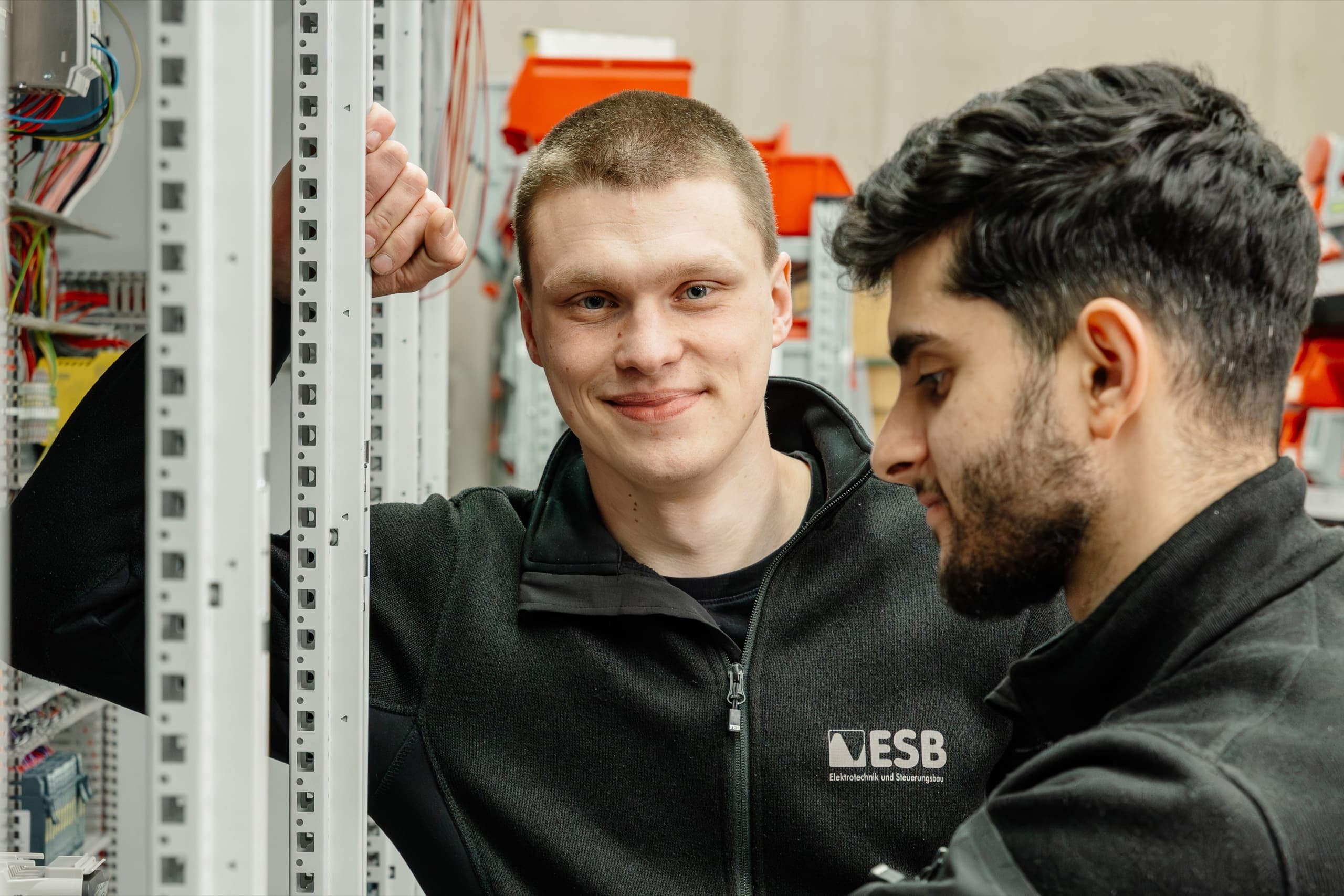Zwei junge ESB Elektriker in Nahaufnahme bei der Schaltschrankbestückung