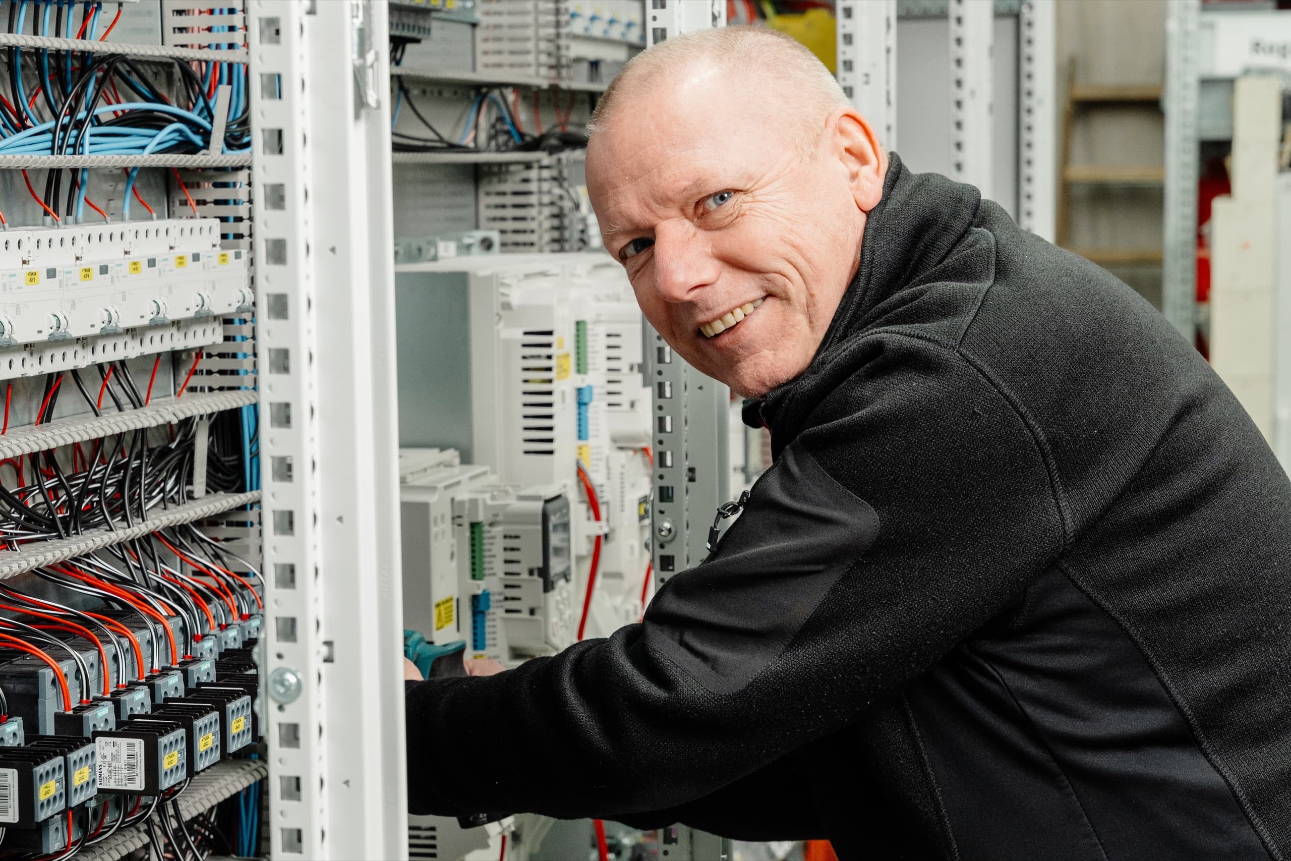 ESB Elektriker verdrahtet Steuerungsschrank mit bunten Kabeln